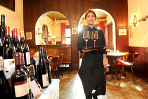Frau mit Tablett auf dem zwei Weingläser stehen © Weinhaus Schreiner