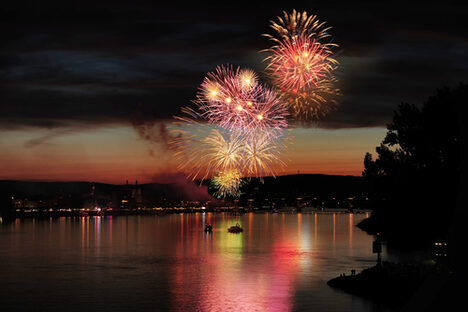 Feuerwerk über dem Rhein vor der Kulisse der Stadt.