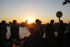 Menschen im Biergarten am Flußufer © Pixabay AnjaPetrol