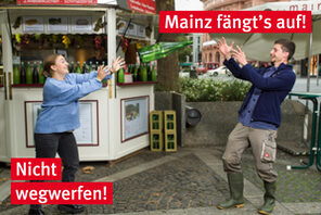 Eine Winzerin wirft einem Winzer eine Weinflasche zu. © Landeshauptstadt Mainz/dreivorzwölf Marketing, Foto: Carsten Costard